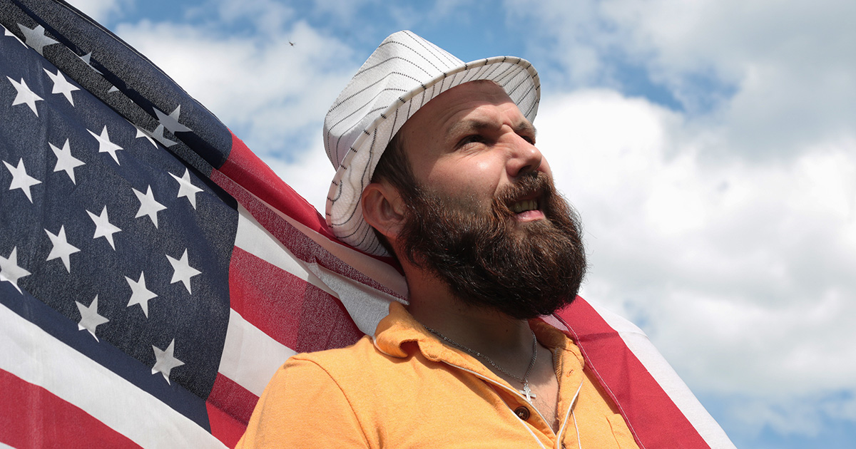 man, beard, fedora, blue sky, america, american flag, wind, billow, heroic, bold, intrusive, pirate, this land is your land, steal, vote, politician, president, politics, dumb, ignorant