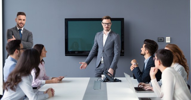 Office Punk Who Always Had Presenters Back Moves Up to Front of Conference Room