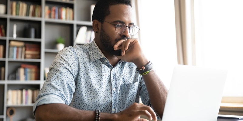 man, glasses, watch, button down, book shelf, laptop, bright, scared, timid, research