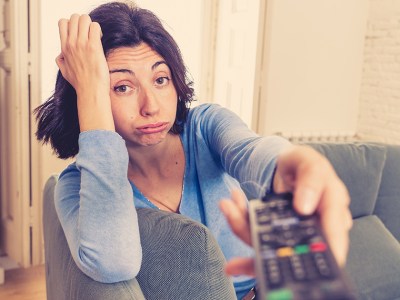 tv remote, watch, woman, blue shirt, v-neck, bored, brunette, sad, couch, lazy, quarantine