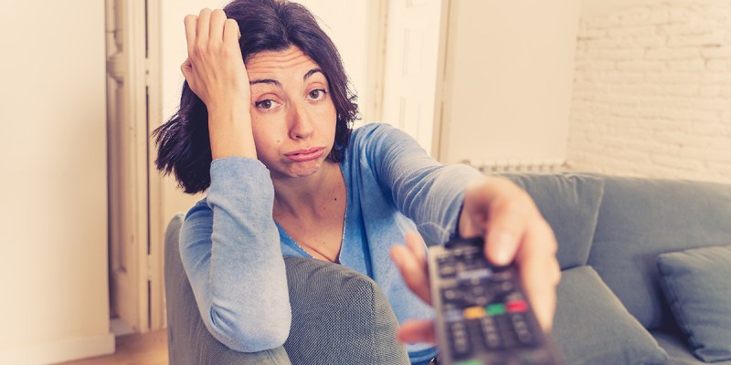tv remote, watch, woman, blue shirt, v-neck, bored, brunette, sad, couch, lazy, quarantine