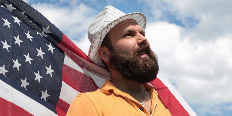 man, beard, fedora, blue sky, america, american flag, wind, billow, heroic, bold, intrusive, pirate, this land is your land, steal, vote, politician, president, politics, dumb, ignorant
