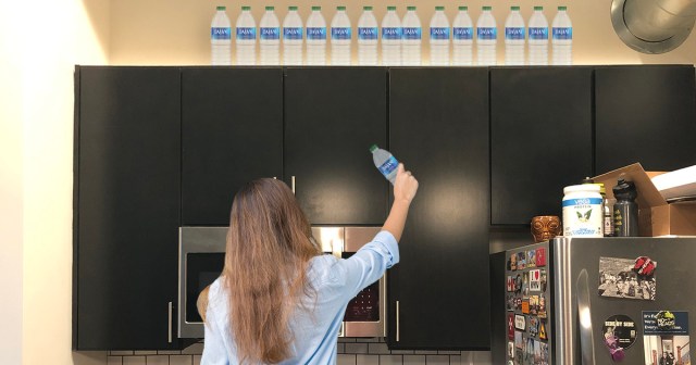Straight Edge Woman Decorates Top of Kitchen Shelves With Empty Dasani Bottles