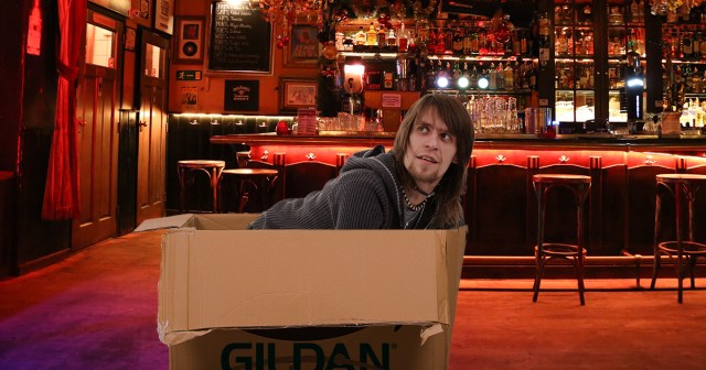 Merch Guy Folded and Crammed Into Box Until Next Gig