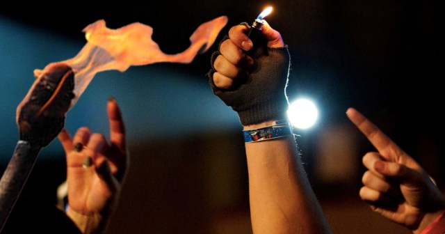 Show-Off at Concert Waving Lit Torch